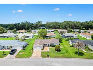 An aerial view of a single-Gathering home showcasing its manicured lawn and serene neighborhood setting at 9853 Se 175Th Pl, Summerfield, FL 34491