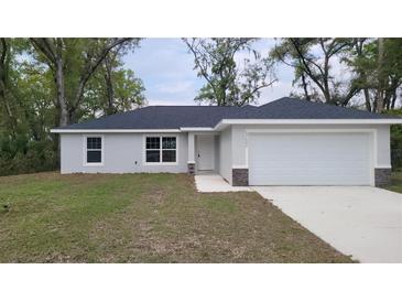 Charming single-story home with a well-manicured lawn and attached two-car garage at 17685 Sw 112Th Ln, Dunnellon, FL 34432