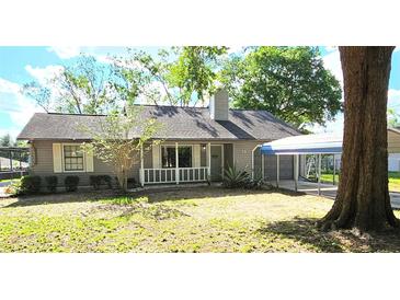 Charming single-story home with a well-maintained lawn, covered carport and gray siding at 70 Almond Pass Dr, Ocala, FL 34472