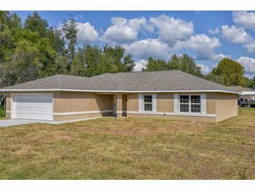 Charming single-story home featuring a neutral color scheme, white shutters and a two-car garage at 8040 Sw 131St Ln, Ocala, FL 34473