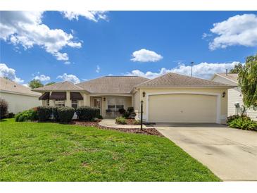 Charming single-story home with well-maintained landscaping and a two-car garage at 8352 Se 168Th Trinity Pl, The Villages, FL 32162