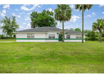 Charming single-story home with lush green lawn and well-maintained landscaping, offering curb appeal at 2521 Nw 45Th Pl, Ocala, FL 34475