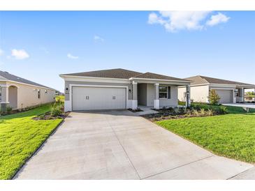 Charming single-story home with a two-car garage, well-manicured lawn, and professionally landscaped front yard at 8816 Sw 69Th Place Rd, Ocala, FL 34481