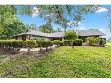 Charming single-story home with well-manicured lawn and mature landscaping, creating a welcoming curb appeal at 8940 Sw 8Th St, Ocala, FL 34481