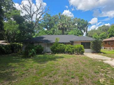 A single Gathering home with mature trees and landscaping in need of yard maintenance at 3264 Ne 17Th Ave, Ocala, FL 34479