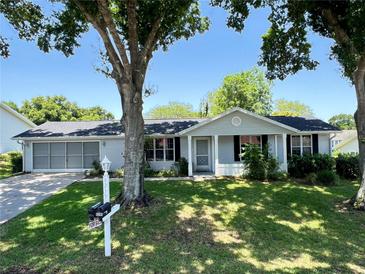 Charming single-story home with a well-manicured lawn and mature trees providing shade at 8239 Sw 108Th St, Ocala, FL 34481