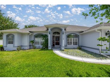 Charming single-story home featuring a well-manicured lawn and inviting front entry with arched window details at 11140 Sw 53Rd Cir, Ocala, FL 34476