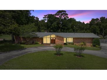 Charming single-story brick home featuring a circular driveway and mature landscaping at 1852 Ne 39Th Ct, Ocala, FL 34470