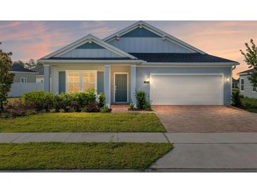 Charming single-story home with a well-manicured lawn and a brick driveway leading to an attached two-car garage at 1875 Nw 44 Court Rd, Ocala, FL 34482