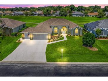 Beautiful home featuring a well-manicured lawn, arched windows, a three-car garage, and lovely landscaping at 2478 Nw 53Rd Avenue Rd, Ocala, FL 34482