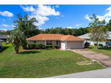 Charming single story home with a well manicured lawn and an attached two car garage at 4992 Nw 31St St, Ocala, FL 34482