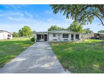 Charming home with a well-manicured lawn, long driveway, and covered front porch with a lovely country motif at 8973 Sw 103Rd Ln, Ocala, FL 34481