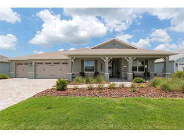 Charming single-story home with manicured front yard, covered porch, and three-car garage at 9577 Sw 82Nd Street Rd, Ocala, FL 34481