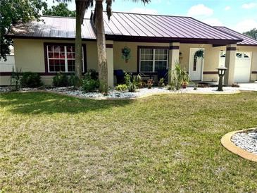 Well maintained single story home with green grass, palm trees and white rock landscaping at 340 Oak Track Loop, Ocala, FL 34472