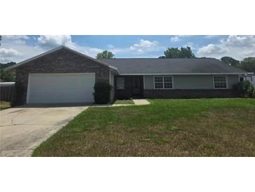 Charming single-story home featuring a brick facade, attached garage, and well-maintained lawn at 5525 Se 43Rd Ct, Ocala, FL 34480