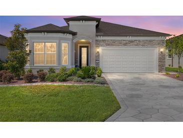 Charming single-story home boasts stone accents, a well-manicured lawn, and a two-car garage with beautiful pavers at 5728 Sw 90Th Court Rd, Ocala, FL 34481