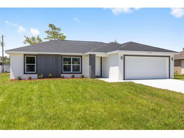 Charming single-story home featuring a gray accent wall and a well-manicured lawn at 16697 Sw 30 Avenue Rd, Ocala, FL 34473