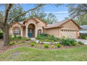 Charming single-story home with a lush landscaped front yard and inviting arched entryway at 19586 Sw 84Th Pl, Dunnellon, FL 34432