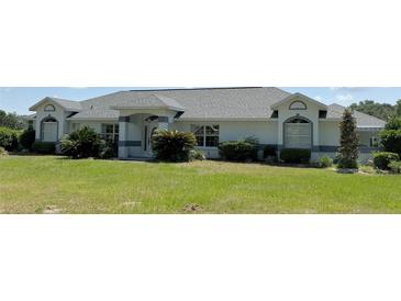 Charming single-story home featuring a well-manicured lawn and beautiful landscaping at 6925 Nw Highway 225A, Ocala, FL 34482