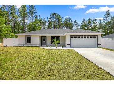 Charming single-story home featuring a freshly manicured lawn and a two-car garage at 15350 Sw 30Th Street, Ocala, FL 34481