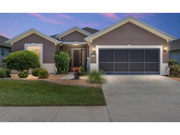 Charming home exterior with a manicured lawn and a two-car garage, great curb appeal and design at 7333 Sw 98Th Ct, Ocala, FL 34481