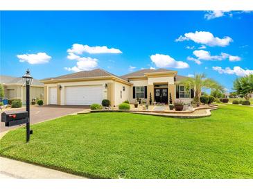 Charming home featuring a well-manicured lawn and attractive landscaping at 11871 Se 91St Cir, Summerfield, FL 34491