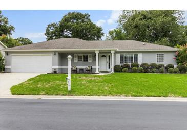 Charming single-story home featuring a well-manicured lawn, neutral paint, and a welcoming front porch at 14481 Sw 112Th Cir, Dunnellon, FL 34432