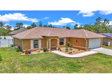 Charming single-story home featuring a well-manicured lawn and inviting front garden at 16969 Sw 40Th Cir, Ocala, FL 34473