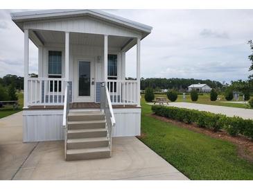 Charming cottage-style home with a cozy porch and well-maintained landscaping in a serene community setting at 4345 Nw 27Th Pl, Ocala, FL 34482