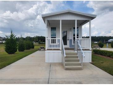 Charming single-story tiny home with a covered porch and manicured lawn at 4345 Nw 27Th Pl, Ocala, FL 34482