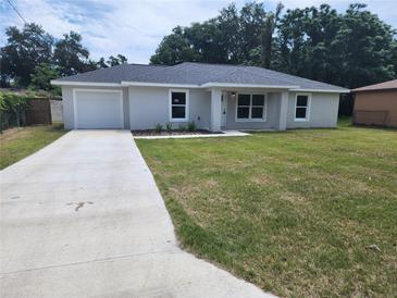 Charming one-story home with a well-manicured lawn and a concrete driveway at 541 56Th Ct, Ocala, FL 34482