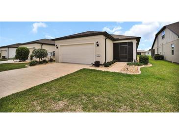 Well-maintained home featuring an attached two-car garage and a screened-in porch at 6051 Sw 93Rd Cir, Ocala, FL 34481