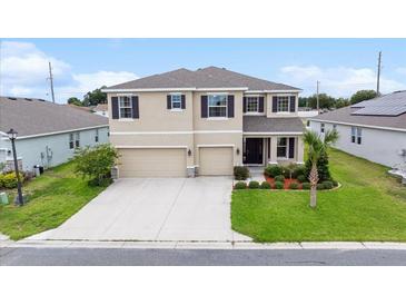 Two-story home showcasing manicured landscaping, a two-car garage, and an inviting front porch at 8110 Sw 59Th Ter, Ocala, FL 34476