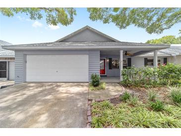 Charming home with a well-manicured lawn, attached garage, and a welcoming red front door at 8745 Sw 92Nd St # B, Ocala, FL 34481
