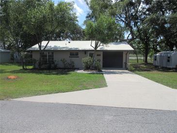 Charming single-story home with a well-maintained lawn, mature trees, and a concrete driveway at 1675 Se 190Th Ave, Silver Springs, FL 34488