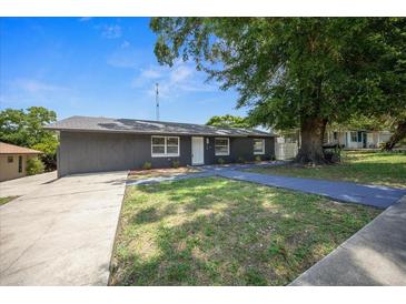 Charming single-story home with gray siding, a lush front yard, and a driveway at 219 Marion Oaks Ln, Ocala, FL 34473