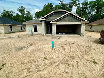 New construction home features concrete block construction, attached two-car garage, and modern architectural details at 3143 Ne 46Th Ave, Ocala, FL 34470