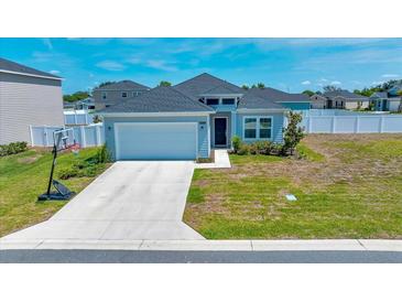 Charming single-story home with a well-maintained lawn and attached two-car garage and a basketball hoop at 5621 Sw 90Th Ln, Ocala, FL 34476