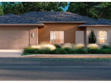 New construction home featuring a gray roof, wood style siding, an attached garage, and curb appeal landscaping at 7027 Sw 128 S, Ocala, FL 34473