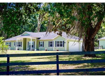 Charming single-story home with a two-car garage, well-manicured lawn, and tasteful landscaping at 10208 Se 170 Pl, Summerfield, FL 34491
