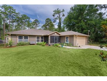 Charming single-story home boasts lush lawn, screened entry, and attached garage at 14330 Sw 79Th Ter, Ocala, FL 34473