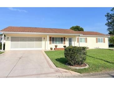 Charming single-story home featuring a well-maintained front yard and attached two-car garage at 17574 Se 95Th Ct, Summerfield, FL 34491