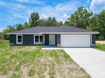 Charming single-story home featuring a well-maintained lawn and a spacious two-car garage at 22777 Sw Beach Blvd, Dunnellon, FL 34431