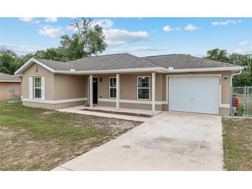 Charming single-story home featuring a cozy porch, neutral-toned exterior, and attached one-car garage at 2690 Sw 154Th Ln, Ocala, FL 34473