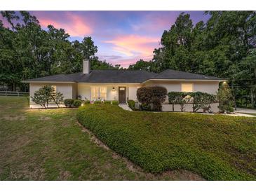 Charming single story home featuring a well manicured lawn, mature trees, and neutral color palette at 3880 Sw 6Th Ave, Ocala, FL 34471