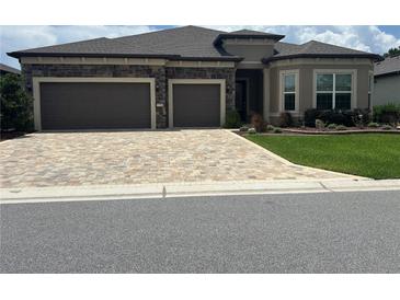 Charming single-story home featuring a two-car garage, stone accents, paver driveway, and well-maintained landscaping at 9394 Sw 60Th Lane Rd, Ocala, FL 34481