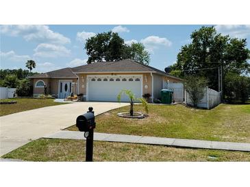 Charming single-story home features a two-car garage, manicured lawn, and inviting entryway at 1129 Wilmington Dr, Deltona, FL 32725