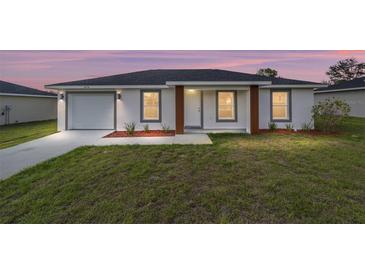 Charming single-story home with a well-manicured lawn and inviting front entrance at 15424 Sw 27 Ln, Ocala, FL 34481