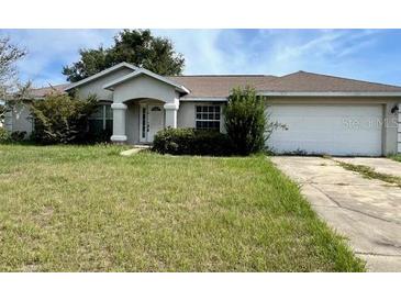 Charming single-story home featuring a well-maintained lawn and an attached two-car garage at 1575 Ne 160Th Pl, Citra, FL 32113