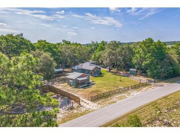 Charming home with lush landscaping, a detached garage, and a fenced yard, offering privacy and curb appeal at 1839 Cr 543A, Sumterville, FL 33585